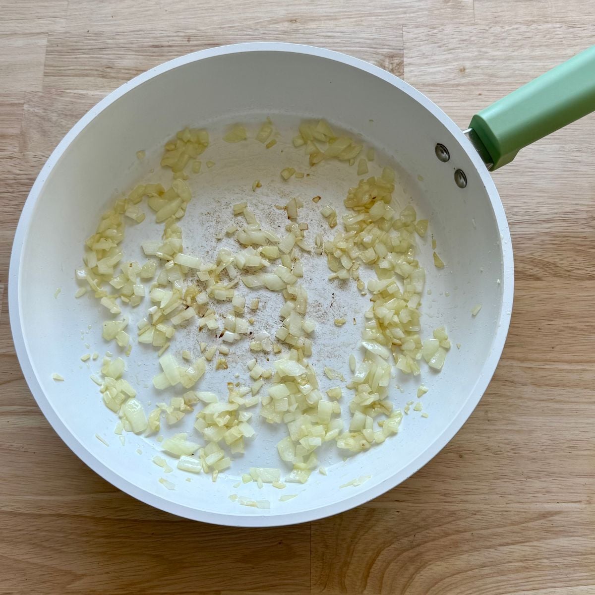 A skillet with sautéed onion and garlic.