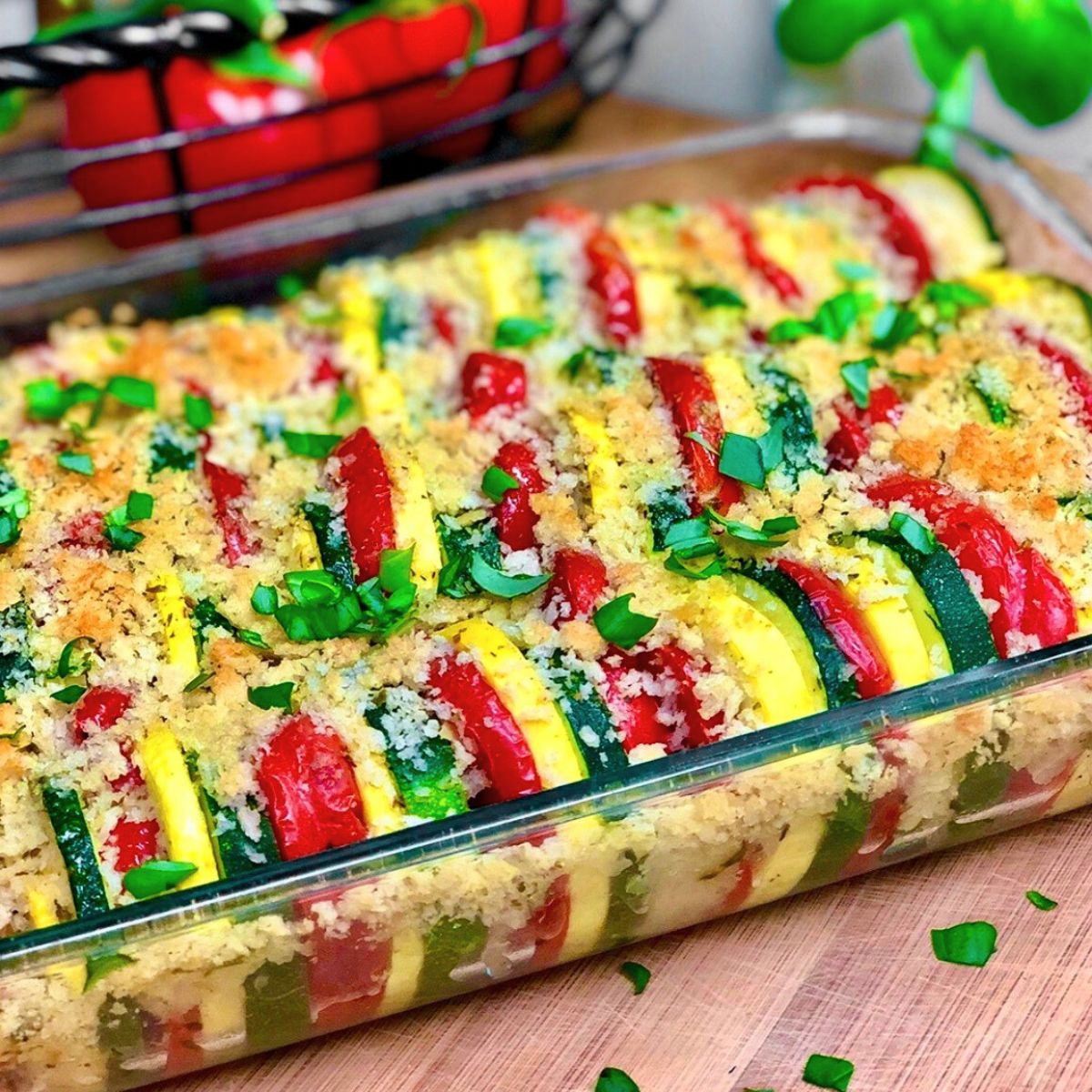 A garden zucchini squash casserole with tomatoes in a glass baking dish.