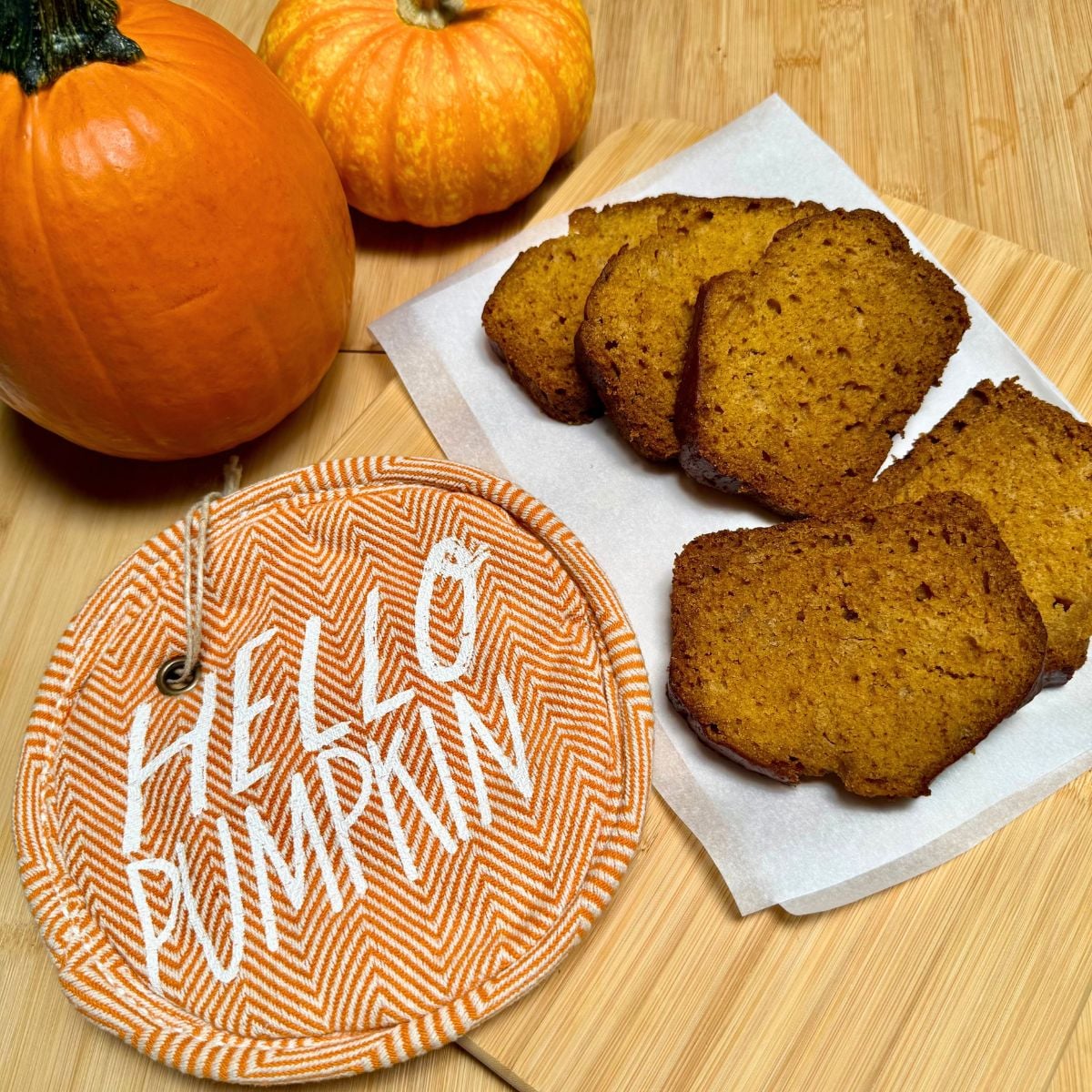 A sliced loaf of vegan pumpkin bread with applesauce.