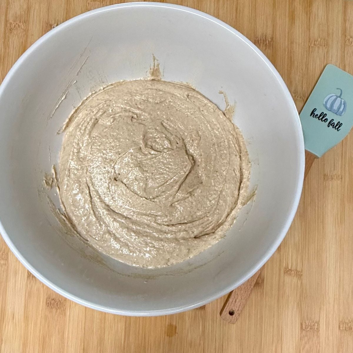 A mixing bowl filled with batter for a vegan applesauce cake.