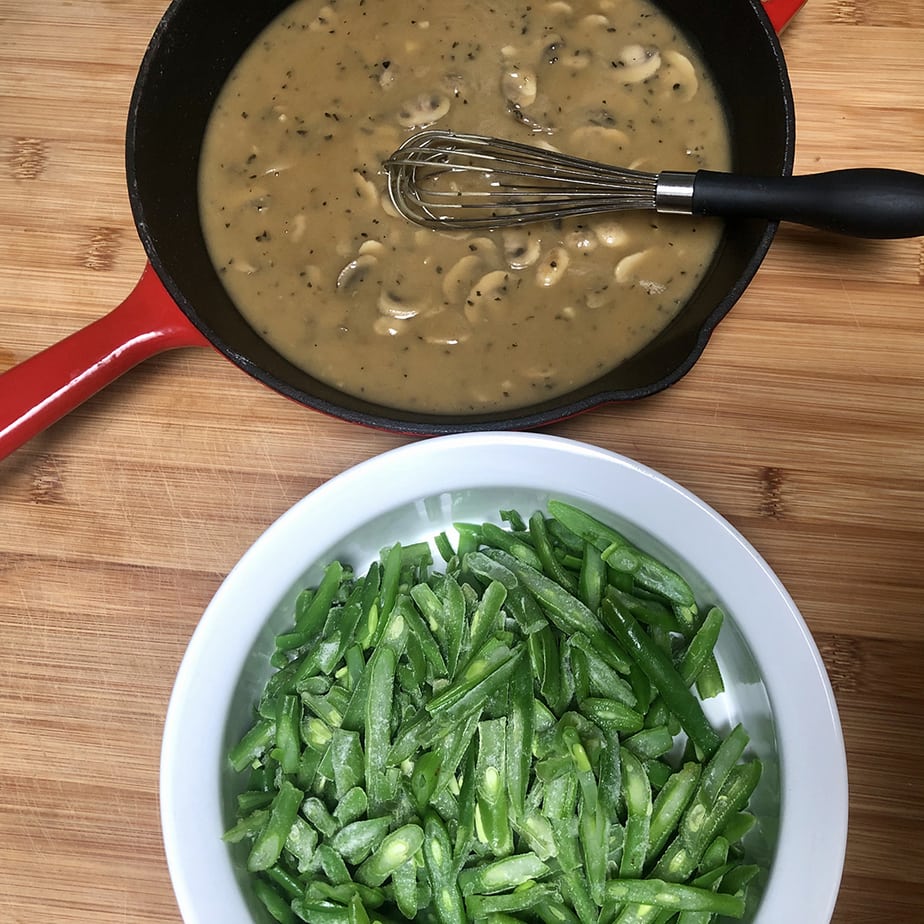 A skillet with vegan mushroom gravy and a dish with green beans.