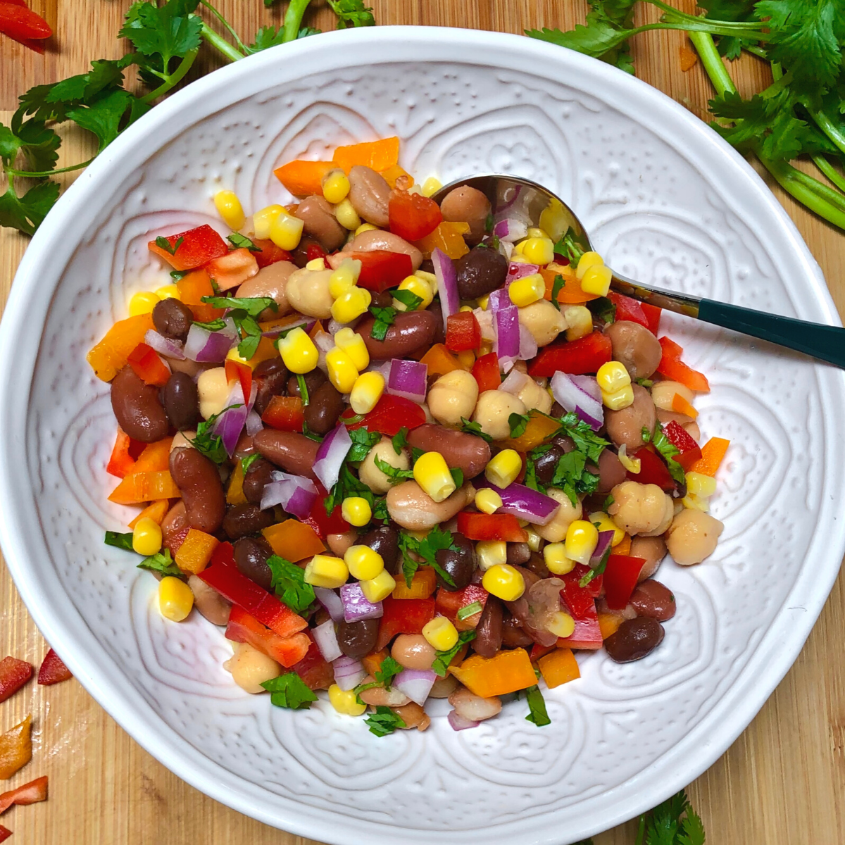 Vegan bean salad with peppers, corn and cilantro in a bowl.