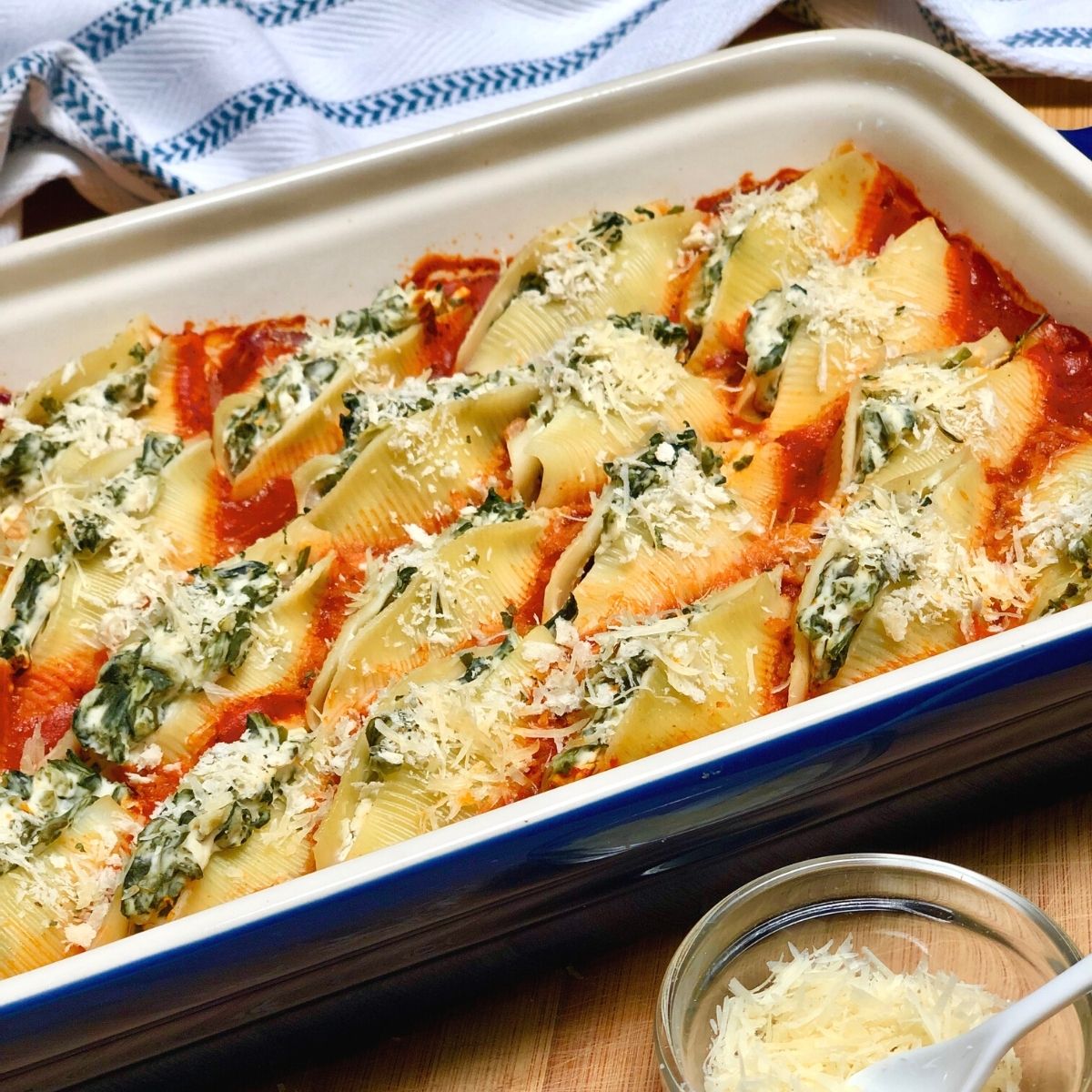 A  baking dish filled with jumbo pasta shells stuffed with vegan ricotta cheese & spinach.