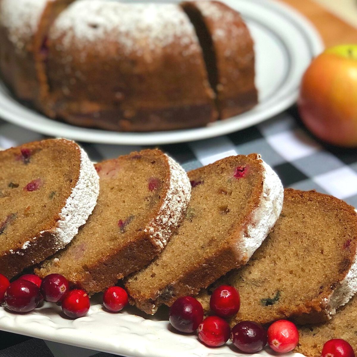 Slices of old fashioned homemade vegan applesauce cake with fresh cranberries.