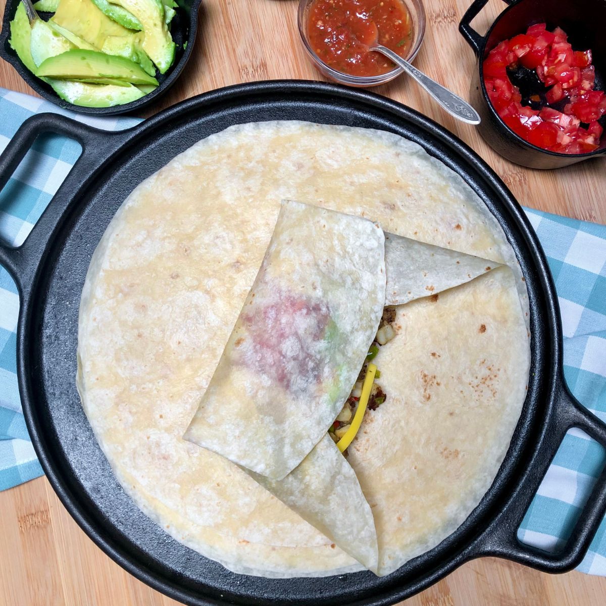 A vegan California breakfast burrito being folded.