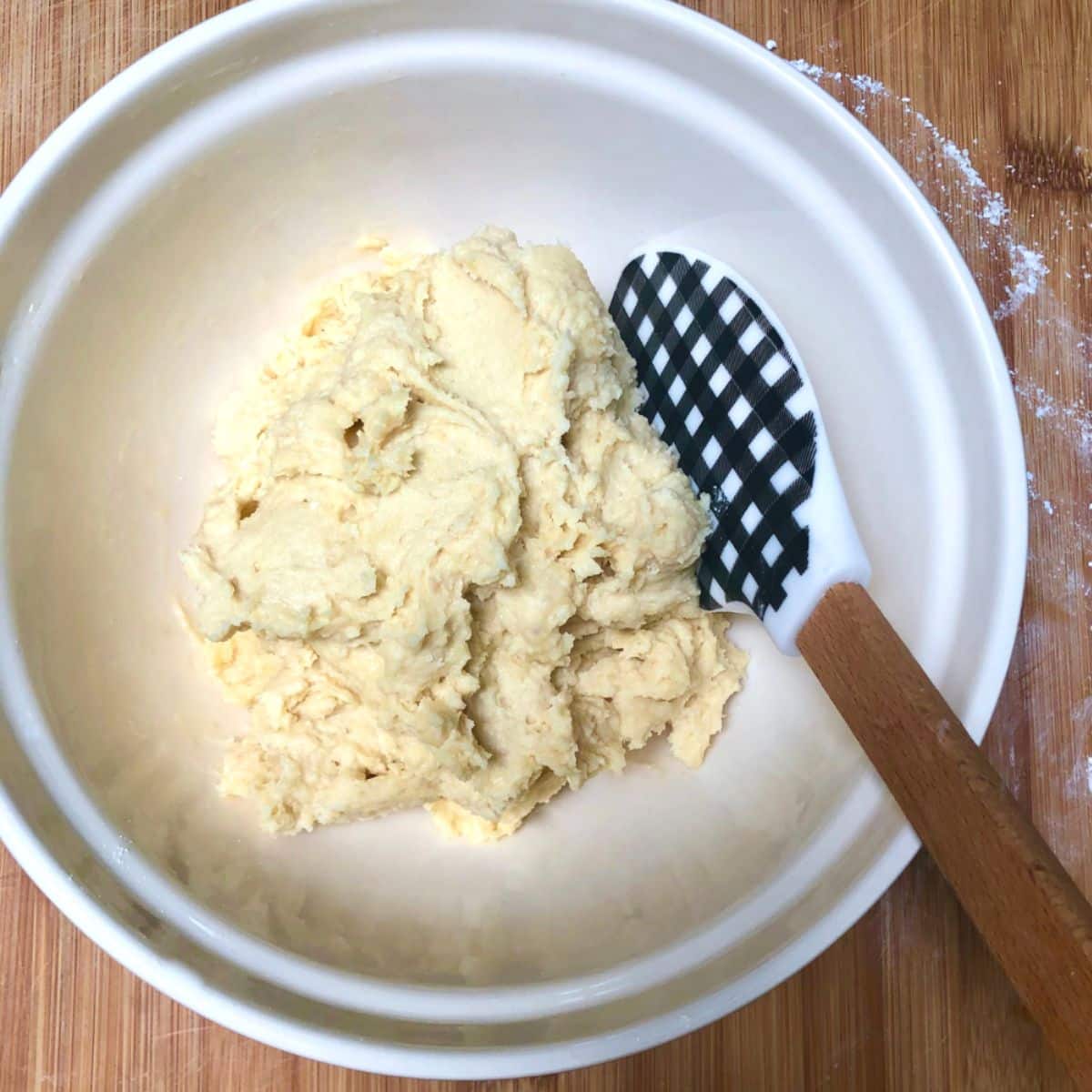A mixing bowl with vegan shortbread dough.