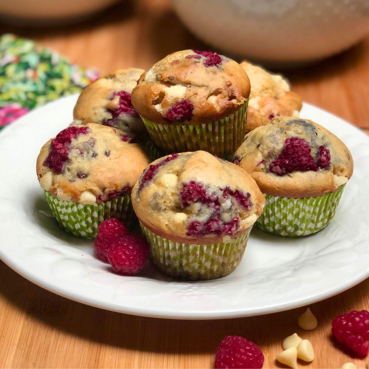 A plate with vegan white chocolate raspberry muffins.