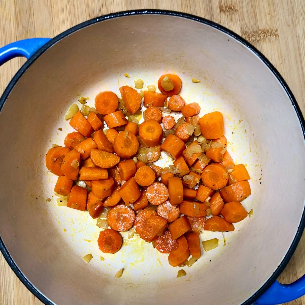 Sautéed carrots, onions, and spices in a soup pot.