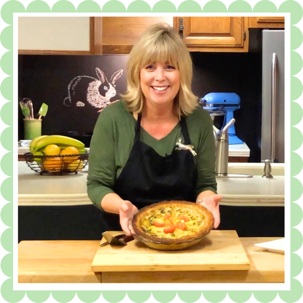 The vegan recipe blogger Connie Edwards McGaughy in her kitchen holding a quiche.