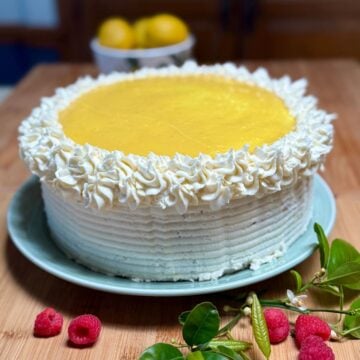 A vegan lemon cake frosted with lemon cream cheese frosting and topped with lemon curd.