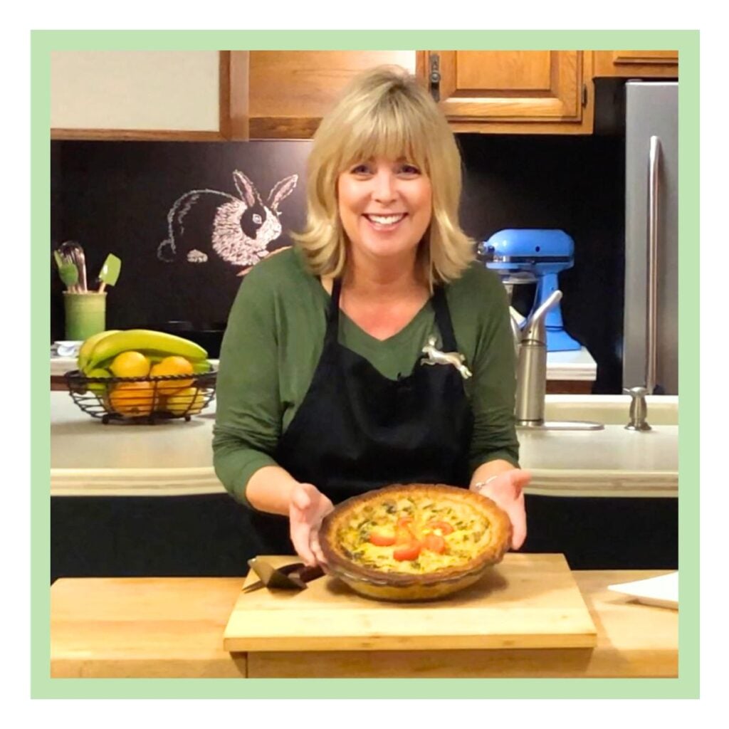 Vegan recipe developer and author Connie Edwards McGaughy in her kitchen holding a quiche.