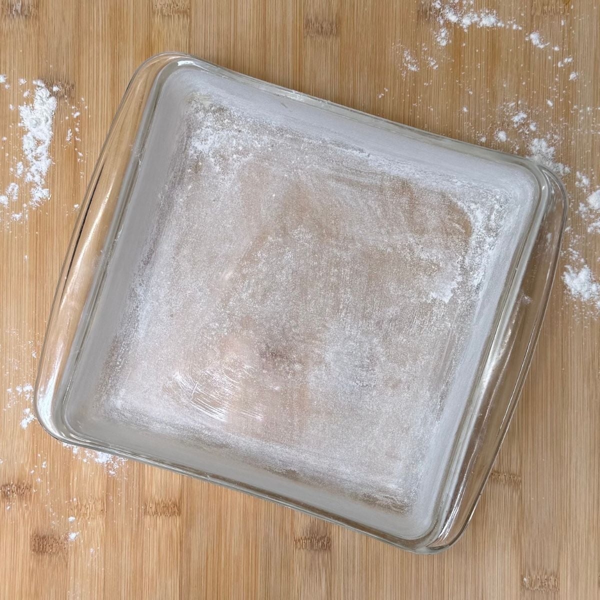 A greased and floured square baking dish.