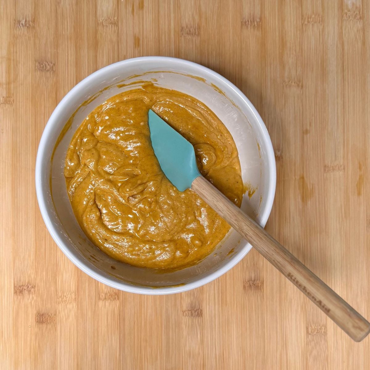 A bowl filled with batter for vegan maple pumpkin muffins.