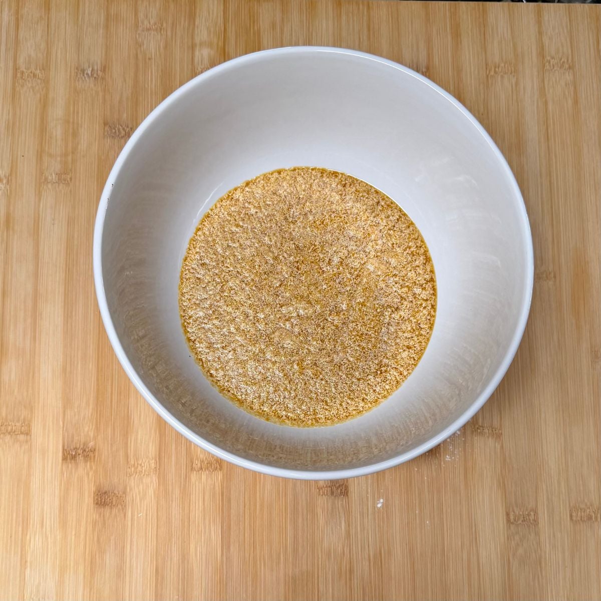 A mixing bowl with wet ingredients for vegan pumpkin cookies.